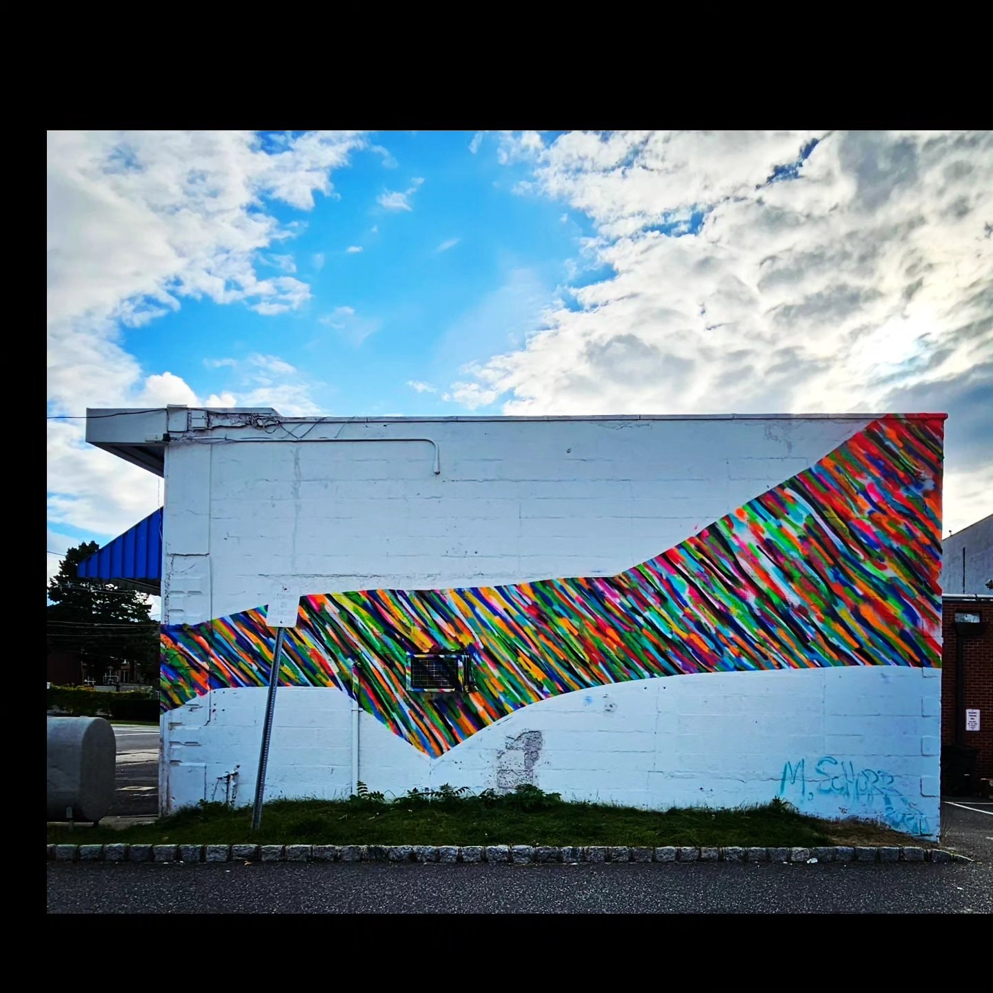 Da Race - colorful diagonal stripe mural on building wall