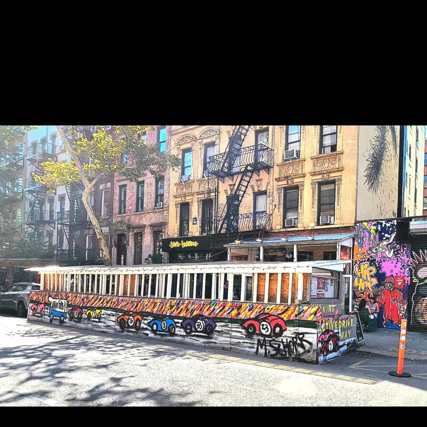 Da Race - NYC street mural with race cars on barrier