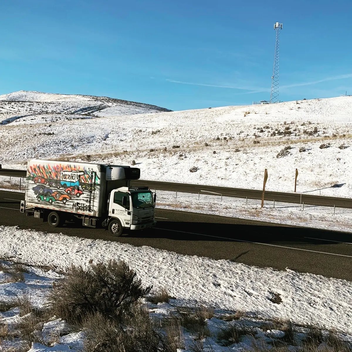 Da Race Moving - art truck on snowy highway with cell tower