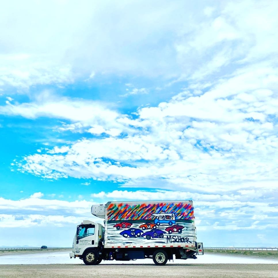 Da Race Moving - art truck on open highway under blue sky